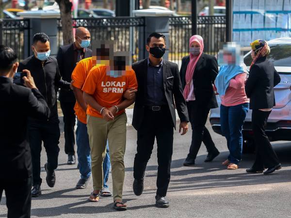 Dua lelaki berbaju lokap oren dan seorang wanita diiring SPRM di mahkamah.