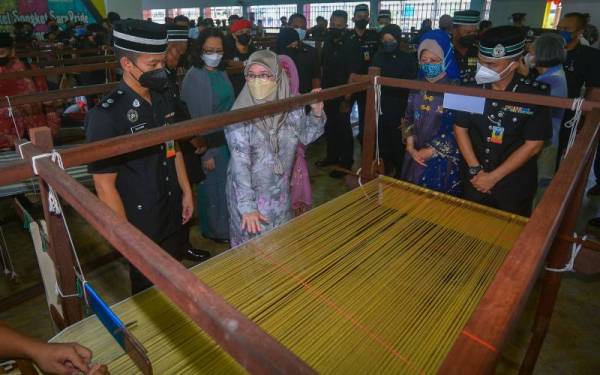 Raja Permaisuri Agong Tunku Hajah Azizah Aminah Maimunah Iskandariah berkenan meninjau proses tenunan songket ketika melawat Pusat Vokasional Industri Songket SaraPride Penjara Puncak Borneo Kuching, hari ini. - Foto Bernama 