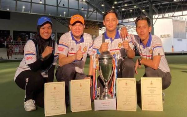 Dari kiri, pasukan lawn bowls UiTM, Farah Irdina, Mohd Nur Shahrin, Alif Saufi dan Mohammad Lokman bersama piala pusingan yang dimenangi pada Kejohanan Lawn Bowls Kuala Lumpur Open Fours 2022 di Kompleks Sukan Negara, Bukit Kiara, Kuala Lumpur.