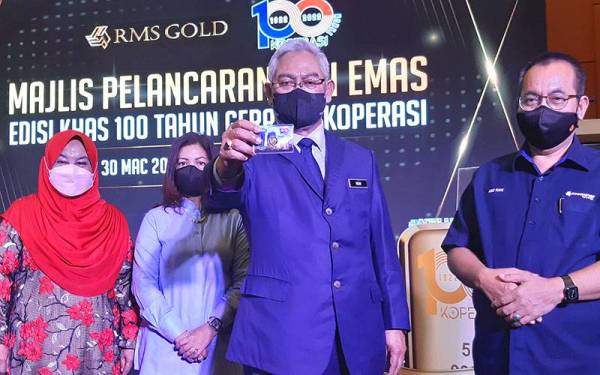 Noh (dua dari kanan) diiringi Abd Rani (kanan) menunjukkan Siri Emas Edisi Khas selepas menyempurnakan majlis pelancarannya di Menara Kembar Bank Rakyat, Kuala Lumpur pada Rabu.