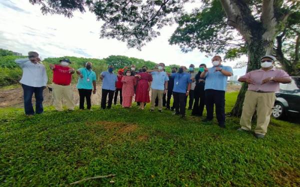 Chen (tengah) bersama penduduk menunjukkan simbol 'thumbs down' sebagai tanda tidak setuju dengan keputusan KKM dan EPU.