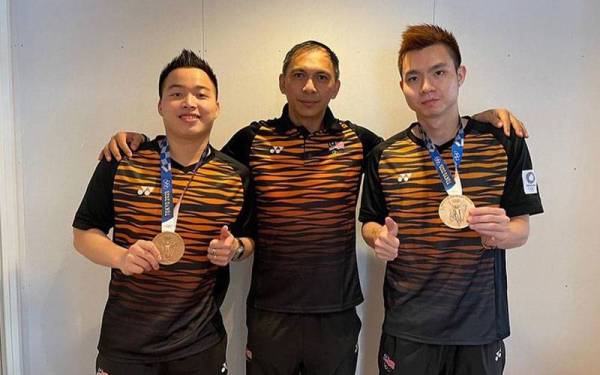 Flandy (tengah) bergambar bersama Aaron-Wooi Yik ketika membantu pasanagn tersebut meraih pingat gangsa di Sukan Olimpik Tokyo.