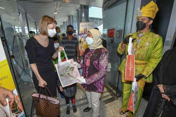 Nancy Shukri (dua dari kanan) menyambut ketibaan pengembara antarabangsa sejurus tiba di Lapangan Terbang Antarabangsa Kuala Lumpur (KLIA) dari Abu Dhabi, Qatar pada hari pertama Malaysia membuka pintu sempadan negara kepada pengembara antarabangsa melalui laluan udara dan darat. - Foto Bernama
