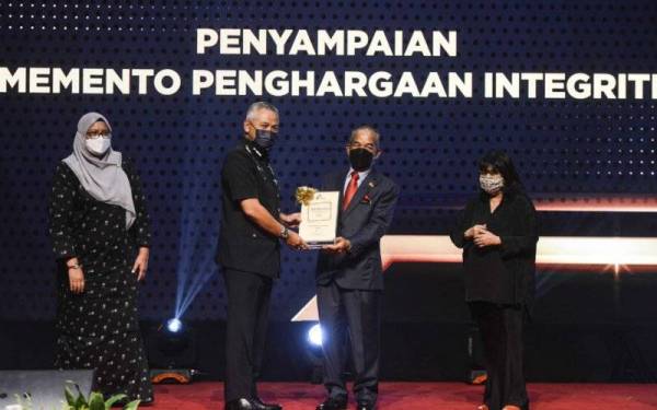 Sidek menyerahkan memento penghargaan integriti kepada Acryl Sani dalam Majlis Apresiasi EAIC Bersama Agensi Penguatkuasaan Seliaan di Pusat Konvensyen Antarabangsa Putrajaya pada Jumaat.