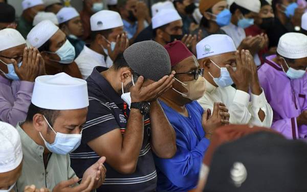 Jemaah mengaminkan doa selepas menunaikan solat Jumaat dalam keadaan tanpa penjarakan fizikal selepas negara memasuki fasa peralihan ke endemik bermula hari ini, semasa tinjauan di Masjid Kampung Gong Tok Nasek. Foto Bernama.