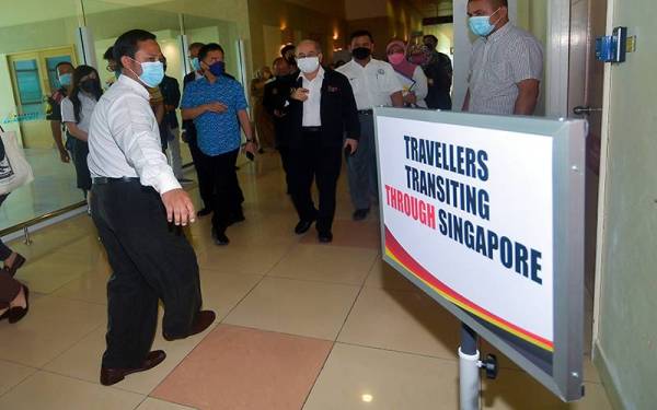 Uggah (tengah) meninjau Simulasi Persediaan Pembukaan Sempadan di Balai Ketibaan Lapangan Terbang Kuching, hari ini. Foto Bernama