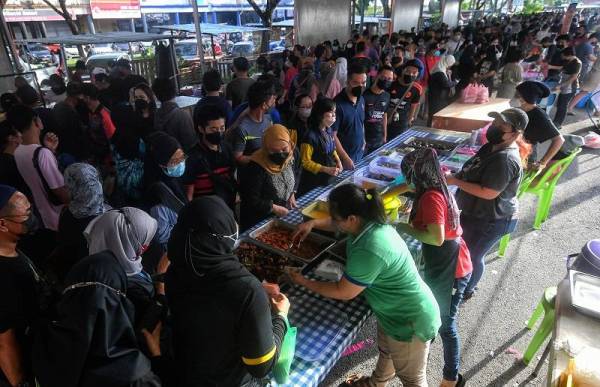 Orang ramai membeli juadah untuk berbuka puasa pada hari pertama pembukaan Bazar Ramadan di Mydin Samariang di Petra Jaya pada Ahad dengan mematuhi SOP seperti pemakaian pelitup muka. -Foto Bernama