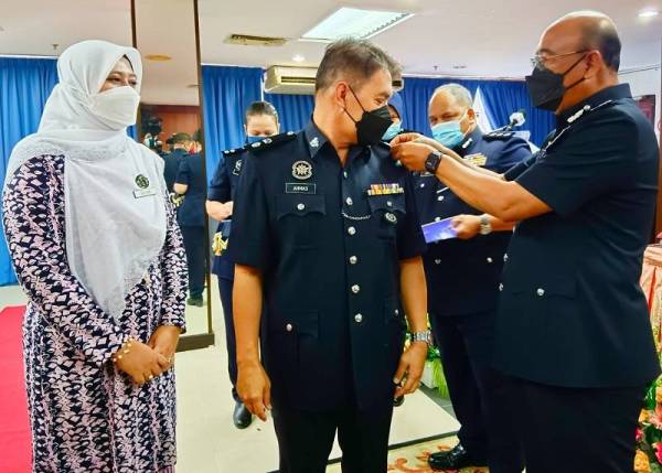 Shafien (kanan) menganugerahkan kenaikan pangkat kepada Ketua Polis Daerah Jeli, Superintanden Ahmad Ariffin (dua dari kiri) pada Majlis Pemakaian Lencana Pangkat Pegawai Kanan Polis Peringkat Kontinjen Kelantan, Kota Bharu pada Isnin.