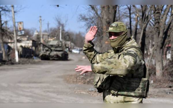 Gambar fail menunjukkan seorang askar Rusia di sebatang jalan di bandar Volnovakha, Ukraine. - Foto TASS