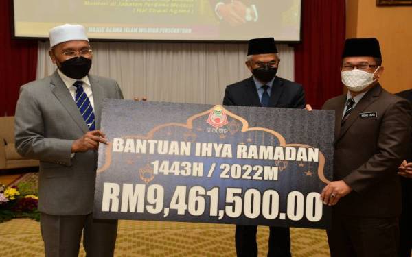 Idris (kiri) menyerahkan bantuan Ihya Ramadan keseluruhan Wilayah Persekutuan bernilai RM9,461,500,00 kepada Pengarah Jabatan Agama Islam Wilayah Persekutuan (Jawi), Datuk Mohd Ajib Ismail (kanan). - Foto Bernama