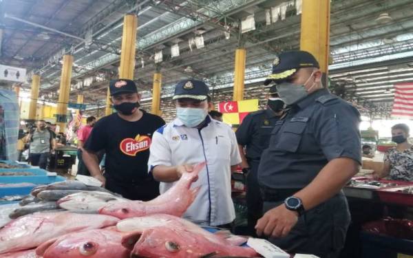 Muhamad Zikril Azan (tengah) mengadakan pemeriksaan Ops Pantau di Pasar Borong Selangor pada Selasa.