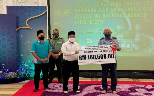 Hayazi (dua dari kanan) menyerahkan replikas cek kepada Affendi pada Majlis Pelancaran Program Agihan Ramadan ATM di Masjid Khalid Al-Walid Kementah, Kuala Lumpur, awal April lepas.