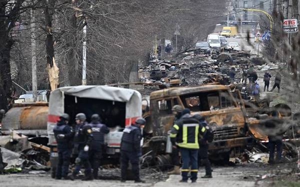 Jurutera lapangan dari Perkhidmatan Kecemasan Ukraine sedang melakukan pembersihan periuk api di jalan raya di Bucha, Ukraine. - AFP