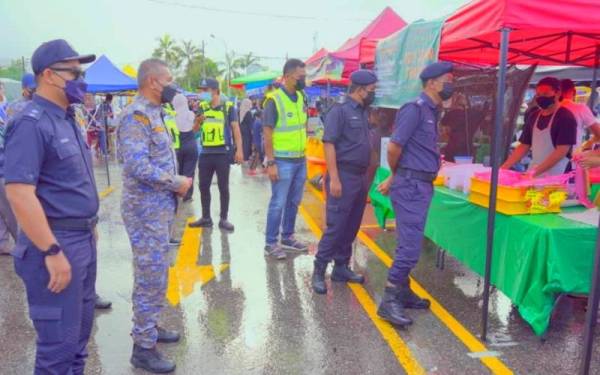 Suzaimi (kanan) turun padang memantau pematuhan SOP di bazar Ramahan Dataran Peladang Kuala Krai dan Batu Jong, Kuala Krai.