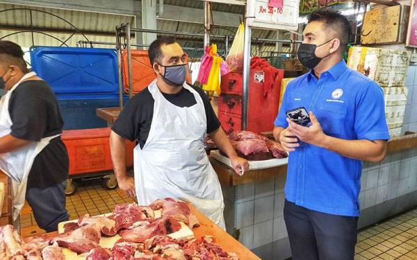 Mohamad Yusrizal (kanan) ketika membuat tinjauan harga barang basah di Pasar Besar Alor Setar pada Khamis.