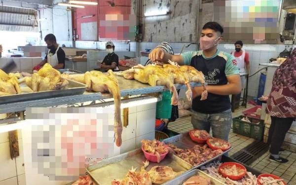 Wan Mohamad Afiq sedang menyusun ayam segar yang dijual di gerainya di Pasar Besar Alor Setar, Alor Setar pada Khamis.