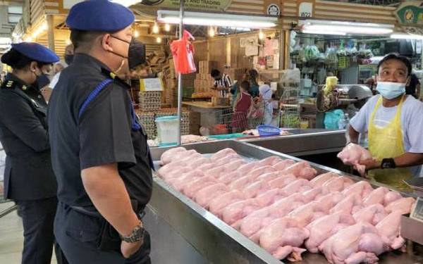 Anggota penguat kuasa KPDNHEP Johor melakukan pemeriksaan ke atas peniaga ayam.