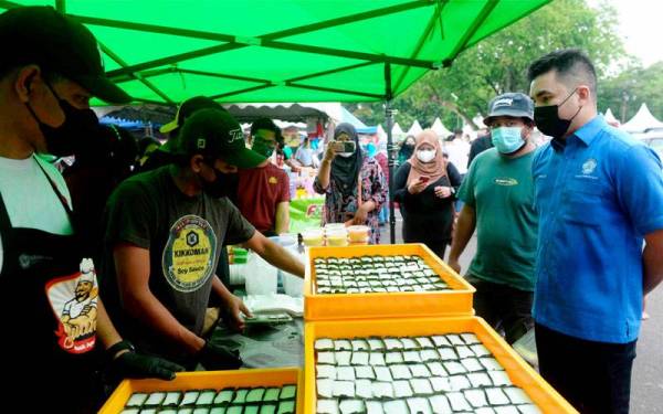 Setiausaha Pengguna Negeri Kedah (CAKE), Mohamad Yusrizal Yusoff (kanan) bertanyakan sesuatu kepada penjual kuih tepung pelita Zulanizan Zakaria, 38, ketika tinjauan harga di Bazar Ramadan Stadium Darul Aman pada Khamis. - Foto Bernama