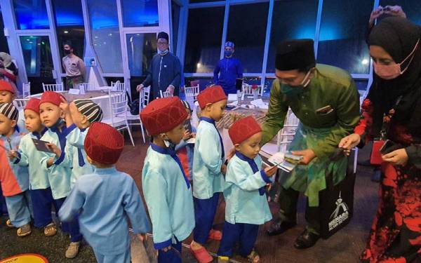 Mohamad Zamri (dua dari kanan) menyampaikan sumbangan kepada anak-anak yatim dari Pusat Jagaan Kanak-Kanak Insan Berkat ketika diraikan dalam majlis berbuka puasa.