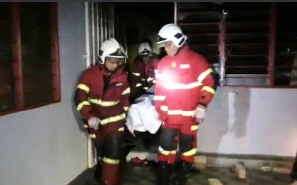 Anggota bomba membantu mengeluarkan mayat mangsa yang maut dalam kebakaran di Kampung Padang Perdana sebelum diserahkan kepada pihak polis untuk tindakan lanjut. Foto: JBPM Pahang