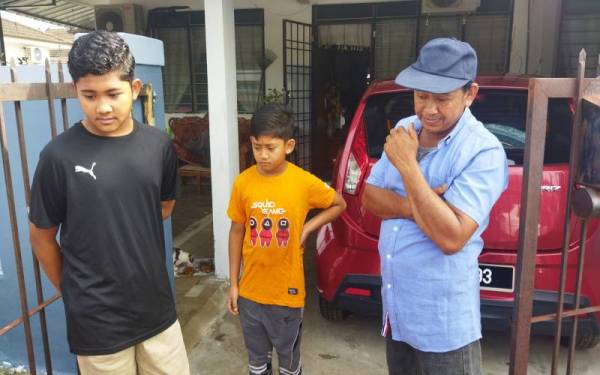 Muhammad Aqil Afif (kiri) dan adiknya, Muhammad Aqif Zahin serta Mohd Nasir menceritakan kejadian yang berlaku ketika ditemui di lokasi kejadian di sini pada Sabtu.