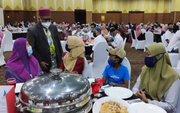 Mohd Khairuddin (berdiri) bertanya khabar ibu tunggal yang hadir pada Majlis Berbuka Puasa Meraikan Ramadan Bersama Ibu Tunggal di Duyong Marina Resort, di sini pada Jumaat.