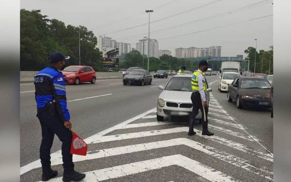 Polis menjalankan operasi mengesan pemandu yang memotong Q di Lebuh Raya Shah Alam (Kesas), Khamis lalu.