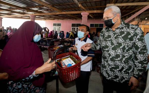 Annuar (kanan) menyampaikan bakul Ramadan kepada masyarakat setempat di Kadok, Kota Bharu pada Sabtu. - Foto: Bernama