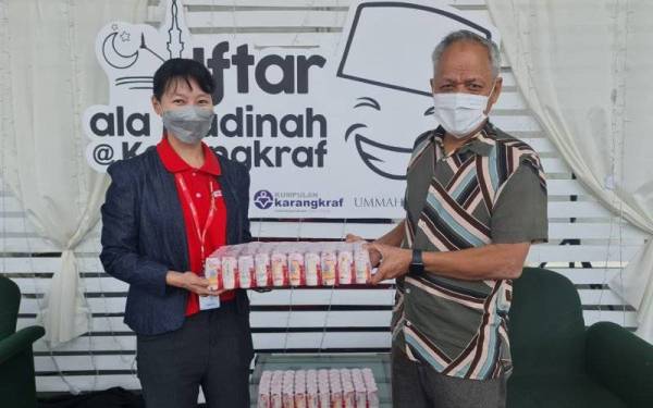 Siew Ling (kiri) menyerahkan minuman Yakult sebagai simbolik kepada Timbalan Pengerusi Lembaga Pengarah Karangkraf, Datuk Muhammad Nasir Hamzah pada Jumaat.