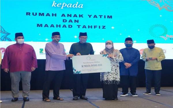 Salleh (dua dari kiri) menyampaikan sumbangan kepada Rumah Anak Yatim dan Maahad Tahfiz pada Majlis Berbuka Puasa Bersama Anak Yatim dan Pengagihan Zakat Kumpulan Qhazanah Sabah di SICC, Kota Kinabalu.