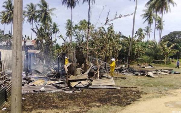 Pasukan bomba berada di lokasi kejadian selepas menerima panggilan berhubung kebakaran membabitkan dua rumah di Kampung Tanjung Labian Sungai Bilis, Lahad Datu.