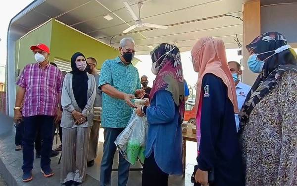 Annuar (tiga dari kiri) mengagihkan Bubur Lambuk Kampung Baharu kepada 1,000 penerima di Bazar Ramadan Peringat, Kota Bharu pada Ahad.