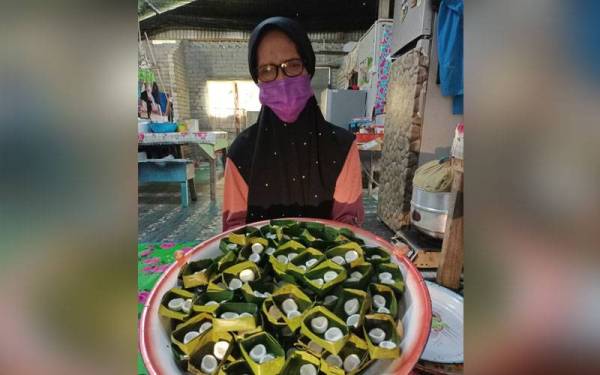 Kuih cecemek yang siap dibulatkan dimasukkan dalam bekas daun pisang untuk diletakkan gula dan santan.