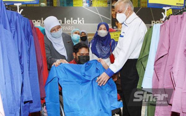 Mohd Najib (tengah) mencuba pakaian baharu dibantu oleh Siti Zailah (kiri) dan Ameer Ali pada program Mydin Prihatin Syawal yang diadakan di Mydin Subang Jaya pada Isnin. - Foto Sinar Harian ROSLI TALIB