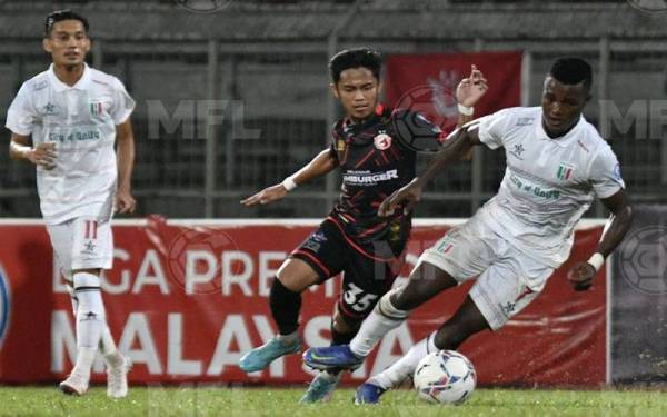 Pemain Kuching City FC, Abu Kamara mengawal bola sambil cuba diasak pemain Kelantan FC di Stadium Negeri, Kuching sebentar tadi. - Foto MFL