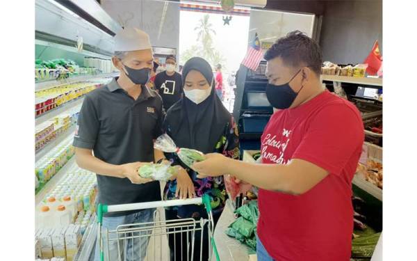 Afif Fariehim (kanan) membawa Nur Alia Maisarah dan bapanya Saifful Anuar Saad,51, membeli barang keperluan di pasar raya berdekatan rumah mereka.