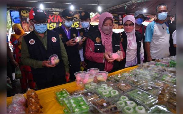 Dr Kasemani (tengah) ketika membuat pemeriksaan di bazar Ramadan Batu Buruk, di Kuala Terengganu, pada Rabu.