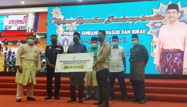 Hamdan (tiga dari kanan) menyampaikan replika cek kepada wakil pengurusan Masjid di Kuantan pada program makmur Ramadan dan Bandaraya Kuantan, sumbangan masjid, surau serta ceramah perdana di Dewan MBK di sini pada Jumaat. 