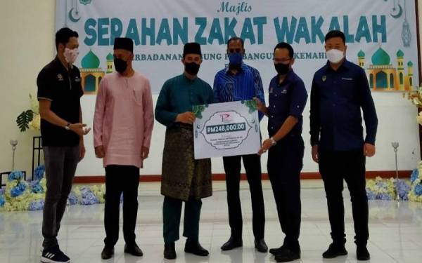 Saravanan (tengah) menyaksikan penyerahan Zakat Wakalah PTPK di Dewan Merdeka Tapah pada Jumaat.