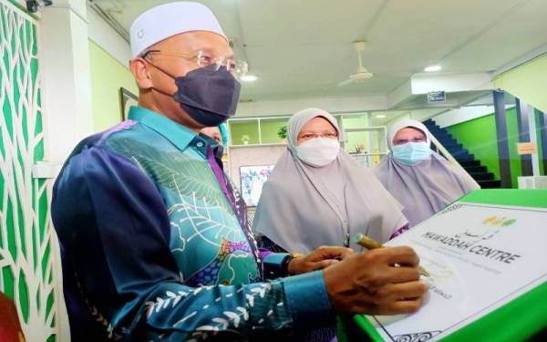 Idris (kiri) merasmikan Pusat Pembangunan Keluarga Mawaddah Kelantan di Kota Bharu sambil disaksikan oleh Mumtaz (dua dari kanan) pada Sabtu.