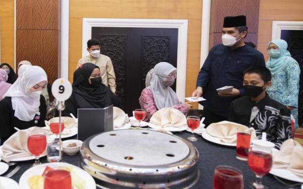 Mohd Radzi (kanan) menyampaikan sumbangan kewangan kepada pelajar tingkatan enam yang hadir di Majlis Ihya Ramadan Bersama Warga Pendidikan Negeri Kelantan, pada Sabtu. - Foto Bernama