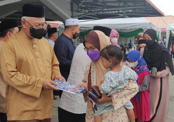 Noh (kiri) menyampaikan sumbangan kepada penerima pada Majlis Penyampaian Sumbangan kepada Anak-Anak Yatim dan Majlis Berbuka Puasa Parlimen Tanjong Karang di Kampung Haji Razali pada Sabtu.