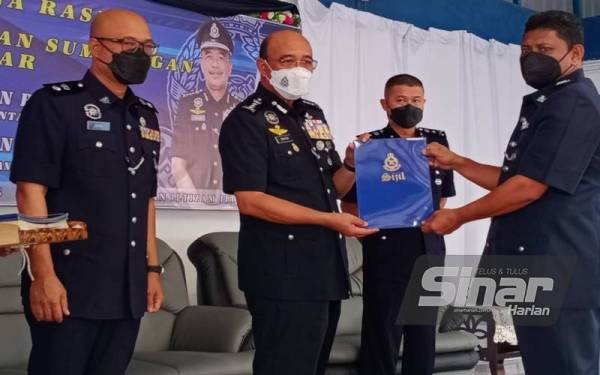 Shafien (dua dari kiri) menyampaikan sijil penghargaan kepada pegawai terpilih sambil disaksikan oleh Zaizul Rizal (kiri) semasa Majlis Penyampaian Sumbangan dan Berbuka Puasa di Ibu Pejabat Polis Daerah (IPD) Pasir Puteh pada Ahad.