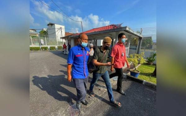 Ammar (tengah) diiringi pegawai penguat kuasa KDN semasa hadir di Mahkamah Majistret Tumpat pada Isnin.