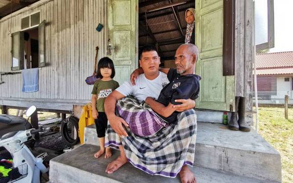 Mohd Farihan bersama bapanya, Ab Hamid ketika ditemui di Kampung Gong Pak Jin, Kuala Nerus dua tahun lalu