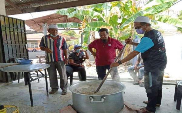 Penduduk 'rewang' menyediakan masakan gerang asam tetel dan daging di Surau Taman Asean 2, Malim.