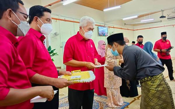 Tengku Mohamad Rizam (tiga dari kiri) menyampaikan sumbangan kepada penerima semasa majlis pengurniaan sumbangan zakat dan fidyah di Masjid Muhammadi pada Selasa.