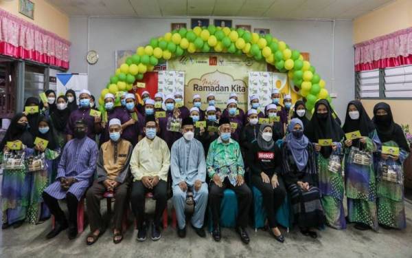 Mohd Firdaus (tiga dari kiri, barisan depan) bersama wakil penganjur meraikan anak-anak yatim di rumah Perkim dengan juadah berbuka puasa McDonald’s, selain sumbangan hamper kuih dan duit raya.