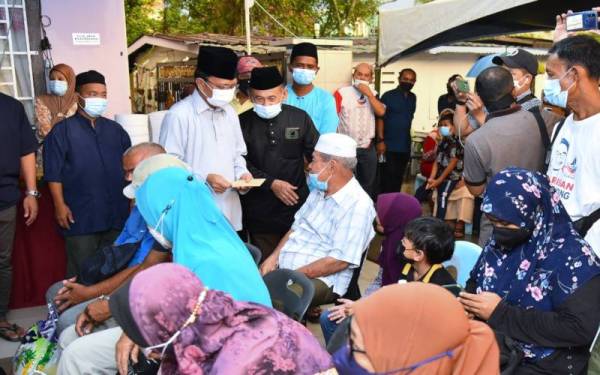 Mohd Shafie menyampaikan sumbangan kepada golongan asnaf di Kampung Sembulan, Kota Kinabalu.