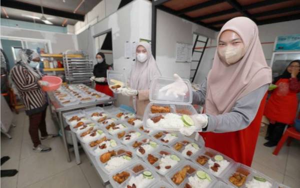 Sukarelawan UIAM membantu membungkus juadah berbuka untuk diagihkan kepada golongan memerlukan di sekitar daerah ini di pusat operasi Dapur Infaq Ummah di Indera Mahkota, pada Rabu.